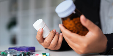 Woman hold bottle of drug tablet painkiller or vitamin supplement reading label ready to organizing...
