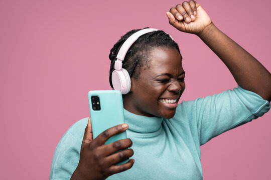 African woman enjoying music with headphones and smartphone
