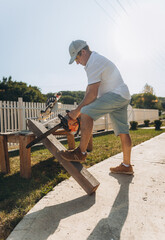 male carpenter cuts a wooden board with an electric saw at home. builder.