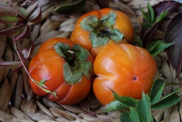 bright background. basket with ripe orange persimmons. beautiful background texture. juicy fruits. vitamins