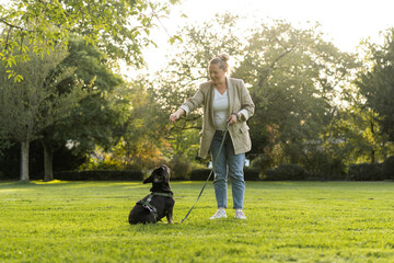 A girl of forty plays in the park with her dog