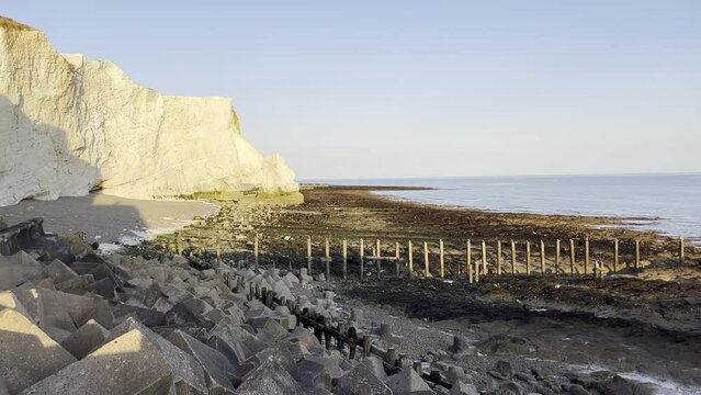 Chalk rock cliffs on the Sussex coast with pebble beach and sea on cloudy morning. Seven Sisters, South of England