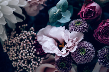 Beautiful bouquet of roses, gypsophila and other different flowers on dark background