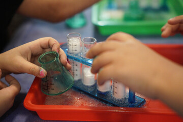 Two little boys doing a science experiment, a science experiment baking soda with vinegar in the...