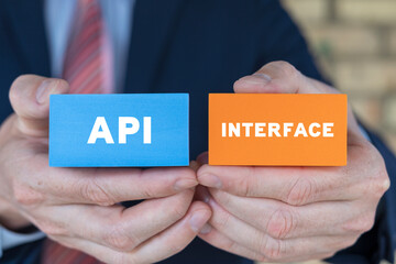 Man holding colorful blocks with inscription: API INTERFACE. Business, internet, web and technology...