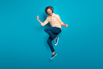 Full size photo of satisfied man with long hairstyle dressed yellow shirt jumping scream yes win...