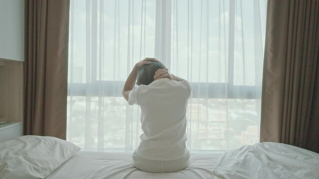 Woman having Neck and Shoulder pain during sitting on bed at home. Muscle painful due to Myofascial pain syndrome and Fibromyalgia, rheumatism, Scapular pain, Cervical Spine. Waking and Health concept