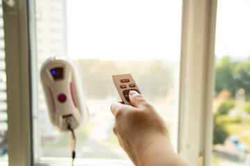 Remote control of a robotic window washer that washes glass from dirt and stains. Copy space for...