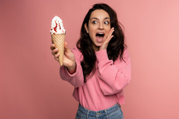 Woman screaming in horror at the sight of the vanilla ice cream waffle cone in her hand while...