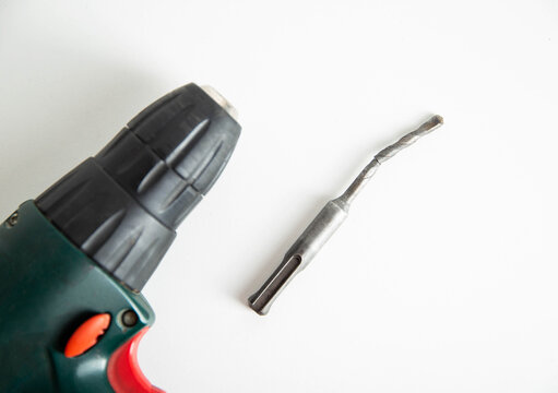 Poor quality broken metal drill on a white background, close-up