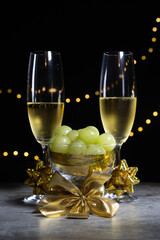 Two glasses of champagne with twelve grapes