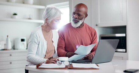 Senior couple, bills and documents on laptop for home mortgage, budget and pension funding in kitchen. Interracial woman and man on computer reading finance paperwork, planning retirement or assets