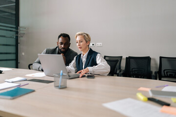 Remote view of female manager insurer consulting black male customer with laptop at meeting. Mature...