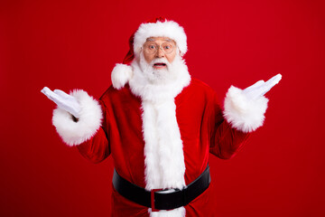 Photo of worried nervous uncertain unsure pensioner santa claus raising hands no answer isolated on...