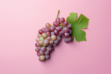 Top view of red grapes on pastel pink background