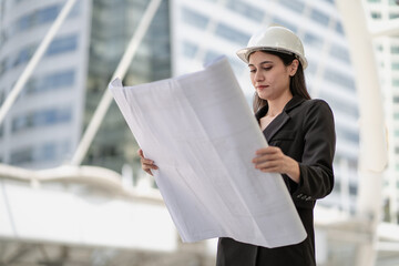 Engineer, architect woman working on housing real estate development project in urban. Female property development designer hold blueprint of residential apartment layout sketch for structure builder