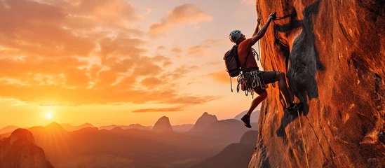 Fotobehang Adventurous Extreme Sport of Rock Climbing Man Rappelling from a Cliff. Mountain Landscape Background with sunset light © Beny
