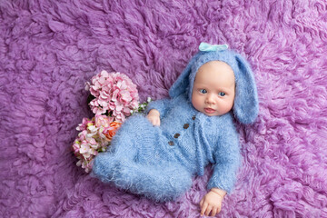 small child in a hare costume on purple fur. Newborn photo shoot girls
