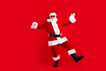 Fototapeta na wymiar Full size photo of good mood grandfather wear santa costume in glasses dancing at christmas celebration isolated on red color background