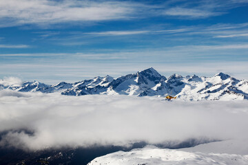 Aerial view of the Italian Alps in winter with snow and clouds.