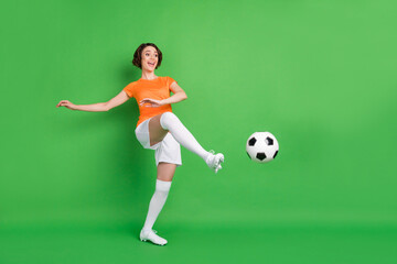 Full size portrait of positive person look empty space foot kick ball have fun isolated on green...