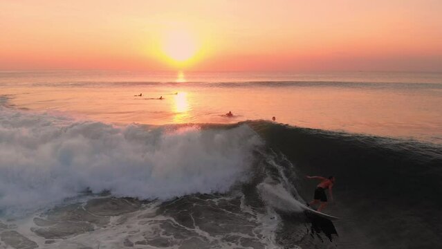 Surfer ride on barrel wave. Surfing at perfect waves with warm sunset light