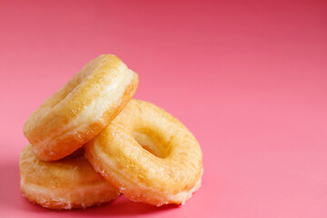 assorted donuts with chocolate frosting, topping sprinkles donuts Colorful variety and Variety of flavors mix of multi colored sweet donuts with frosted sprinkled on pink background. top view