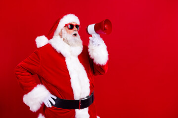 Profile photo of grandfather santa hold loudspeaker toa communicate empty space christmas offer isolated on red color background