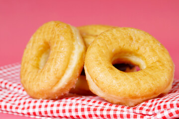 assorted donuts with chocolate frosting, topping sprinkles donuts Colorful variety and Variety of flavors mix of multi colored sweet donuts with frosted sprinkled on pink background. top view