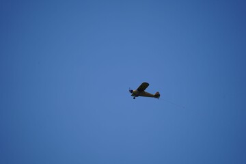 Antique airplane soaring through a crystal-clear, deep blue sky