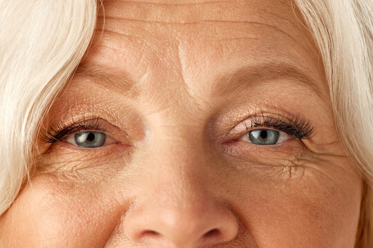 Close-up of senior woman face, eyes with mascara. Beautiful wrinkled face. Natural look and self-care. Concept of natural beauty, aging process, elderly beauty, cosmetology, skincare