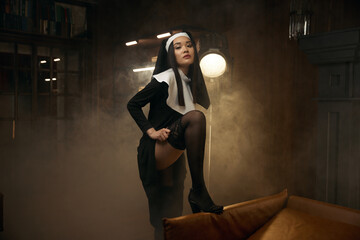 Beautiful sensual woman in nun robe seducing with passionate view - obrazy, fototapety, plakaty