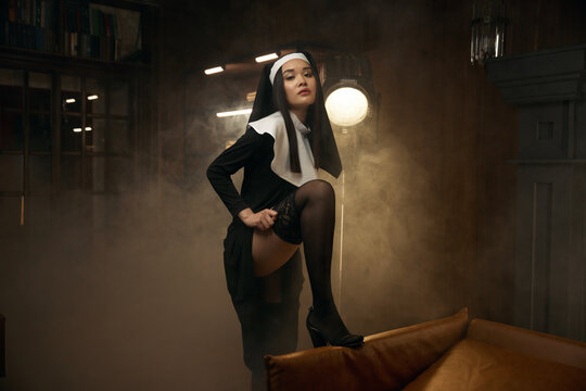 Beautiful sensual woman in nun robe seducing with passionate view