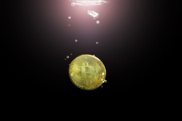 Bitcoin is sinking in water.
BTC coin fell into the water on a black background.
Physical Bitcoin coin close-up underwater. Cryptocurrency is sinking. Bitcoin is falling to the bottom.