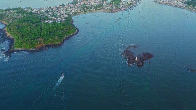 The scenery at the seaport in the fishing village with the fishing boats of Vietnamese fishermen running out in the early morning was filmed from the air. Ocean nature and ships.