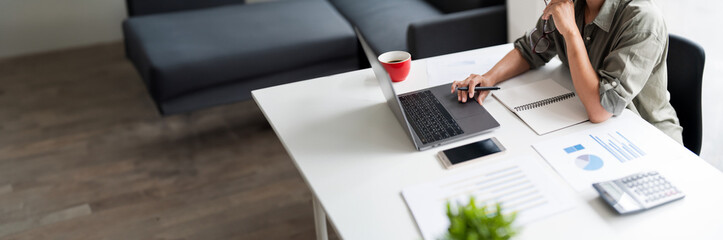 Asian casual businesswoman work to reading growth financial report of new startup project on laptop
