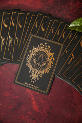 Oracle reading cards on red mat table with candles gemstones plants and encense