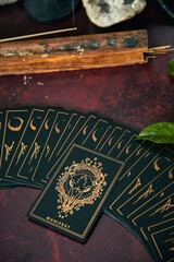 Oracle reading cards on red mat table with candles gemstones plants and encense