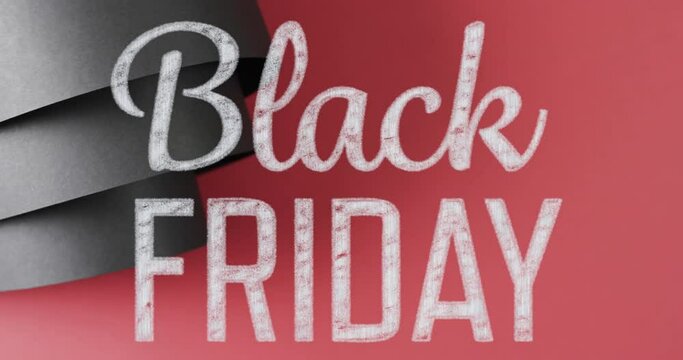 Animation of black friday text over rolled up black paper on red background
