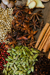 Cinnamon, clove, star anise, cardamom, juniper, nutmeg, ginger and pepper whole spices on a wooden tray