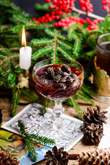 Jam from young pine cones in syrup on a background with pine branches