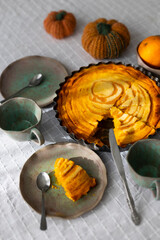 Homemade pumpkin pie with cottage cheese and orange zest and juice served with handmade ceramics - green and pink tea set