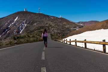 Woman walking in the middle of snowy road