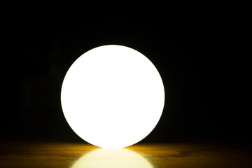 Glowing light bulb on a black background, closeup of photo