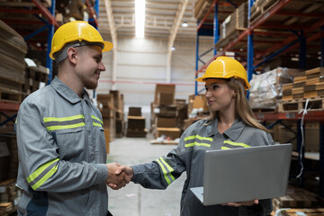 Fototapeta premium Male and female warehouse worker working and discussing in warehouse storage. Warehouse workers inspecting quality of barcodes on shelves pallet