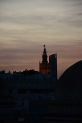 Naklejka premium Giralda de la Catedral de Sevilla, España. De fondo la Torre Pelli iluminada, Torre Sevilla