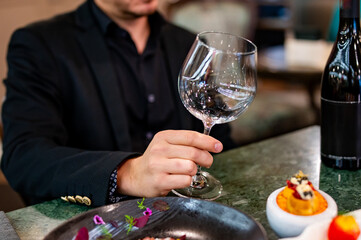 Young man hand holding empty wine glass in a restaurant