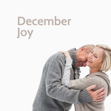 Composite of december joy text over caucasian couple in winter jumpers