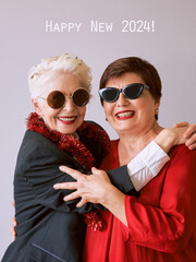 Two beautiful stylish mature senior women celebrating new year. Fun, party, style, celebration...