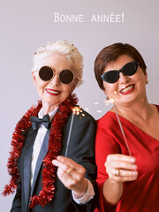 Obraz premium Two beautiful stylish mature senior women celebrating new year. Fun, party, style, celebration concept